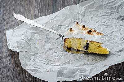 One piece of breton cake with plums and meringue on a wooden table Stock Photo