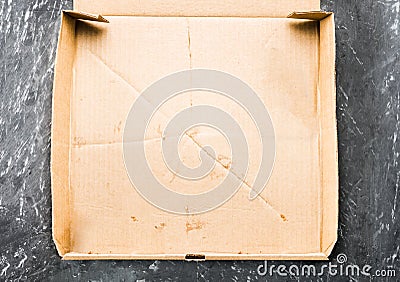 One piece of pizza in cardboard pizza box Top view of empty box with copy space on dark concrete Stock Photo