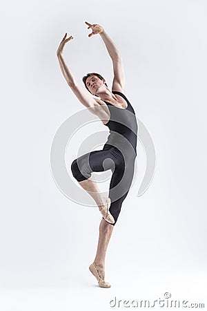 One Professional Male Ballet Dancer Young Man in Black Dance Tights Suit Posing in Ballanced Dance Pose With Lifted Hands in Stock Photo