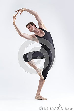 One Professional Male Ballet Dancer Young Man in Black Dance Tights Suit Posing in Ballanced Dance Pose in Studio Stock Photo