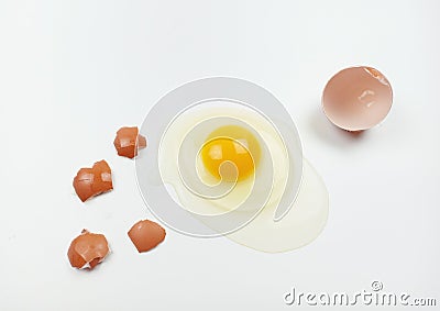 One raw chicken egg with yellow yolk and clear white egg in three layers and broken eggshell in pieces isolated on white Stock Photo