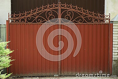 One red closed iron gate with a wrought iron pattern Stock Photo