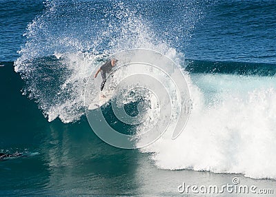 A male surfer executing a slashing backside top-turn off-the-lip at Iluka`s North Wall. Editorial Stock Photo
