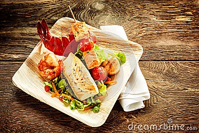 One serving of roasted seafood salad on plate Stock Photo