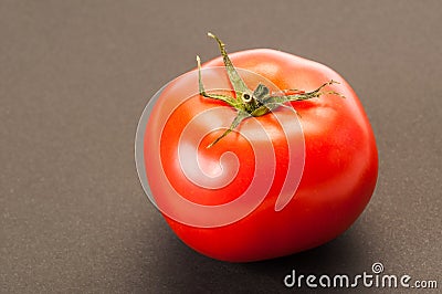 One single perfect red tomato on dark table or background Stock Photo