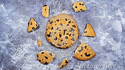 One soft freshly baked chocolate chip cookie with crumbs and chunks on a gray marble kitchen countertop. American traditional Stock Photo