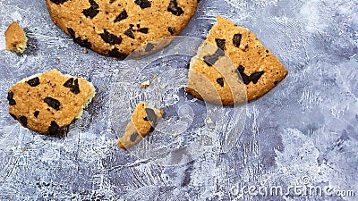 One soft freshly baked chocolate chip cookie with crumbs and chunks on a gray marble kitchen countertop. American traditional Stock Photo