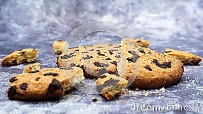 One soft freshly baked chocolate chip cookie with crumbs and chunks on a gray marble kitchen countertop. American traditional Stock Photo