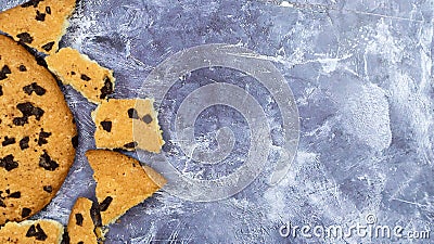 One soft freshly baked chocolate chip cookie with crumbs and chunks on a gray marble kitchen countertop. American traditional Stock Photo