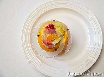 One stuffed orange with mixed fruit salad on a white dish Stock Photo