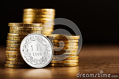 One swiss frank coin and gold money on the desk Stock Photo