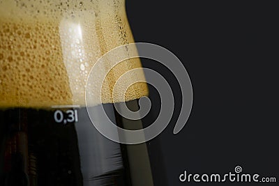 One tall glass of cold dark craft beer over black background. Close up. Copy space Stock Photo