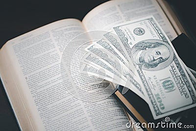 One tenth or tithe is basis on which Bible teaches us to give one tenth of first fruit to God. coins with Holy Bible. Biblical Stock Photo