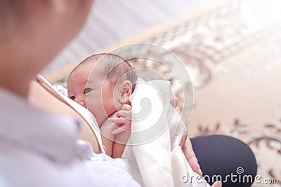 One week little baby girl feeding milk in mother arms. Mother embrace her daughter Stock Photo
