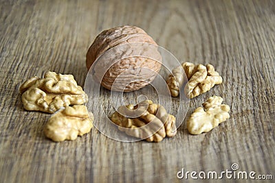 One whole walnut with kernels on wooden background Stock Photo