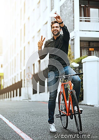 This one will make a great profile picture. Full length shot of a handsome young man taking selfies while traveling Stock Photo