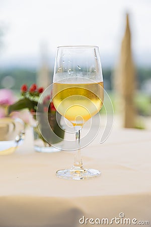 One wineglass with white wine on table with tablecloth Stock Photo