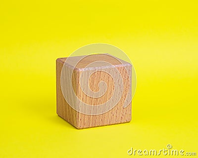 One wooden cube square on yellow background copyspace Stock Photo