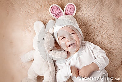 One year old baby lying in bunny hat on lamb wool Stock Photo