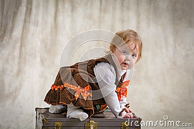 One year old girl on a vintage trunk Stock Photo