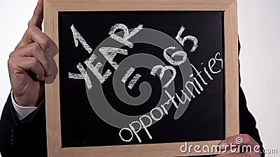 One year is 365 opportunities motivation on blackboard in businessman hands Stock Photo