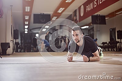 One young man, looking away, plank exercise, gym floor, Stock Photo
