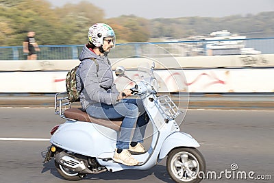 One young man riding a light blue vintage vespa scooter on the city street bridge Editorial Stock Photo