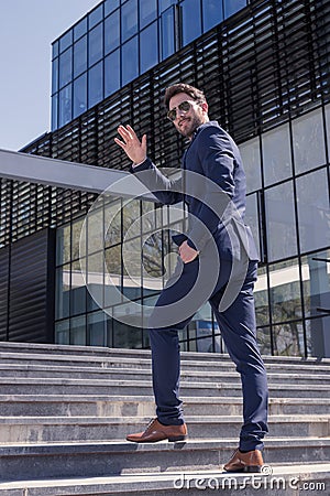 One young man, suit hand waving, back rear view Stock Photo