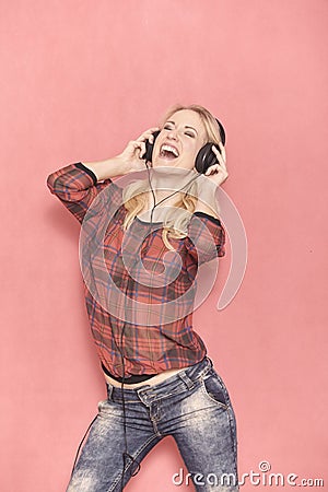 One young woman, hilarious laughing emotion, shouting while listening to music on headphones Stock Photo