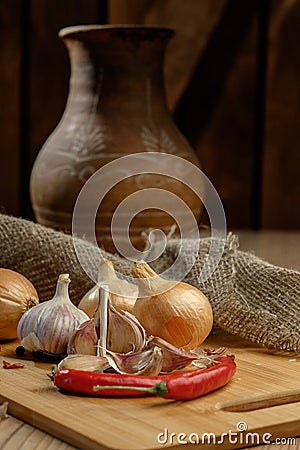 Onions, chili and garlic on a wooden table. Stock Photo