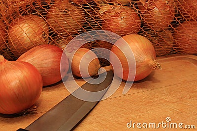 Onions in a sack on a cutting board Stock Photo