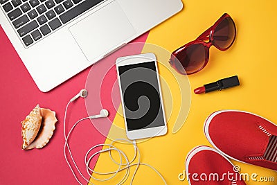 Online booking for summer vacation holiday concept. Smartphone, laptop computer and beach items. View from above. Stock Photo