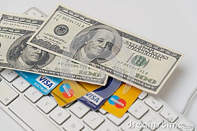 Online Commerce, Ecommerce, credit and debit cards with dollars and a keyboard. Editorial Stock Photo