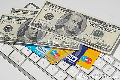 Online Commerce, Ecommerce, credit and debit cards with dollars and a keyboard. Editorial Stock Photo