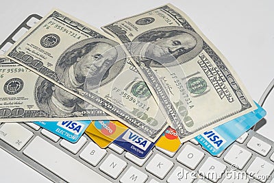 Online Commerce, Ecommerce, credit and debit cards with dollars and a keyboard. Editorial Stock Photo