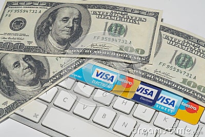 Online Commerce, Ecommerce, credit and debit cards with dollars and a keyboard. Editorial Stock Photo