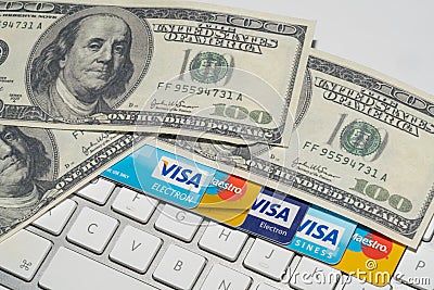 Online Commerce, Ecommerce, credit and debit cards with dollars and a keyboard. Editorial Stock Photo