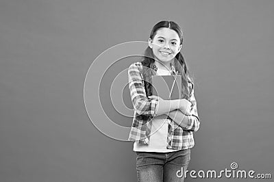 Online courses for kids. Girl child hug textbook orange background. Studying is fun. Extra school course. School concept Stock Photo