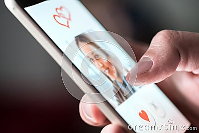 Online dating app in smartphone. Man looking at photo of beautiful woman. Stock Photo