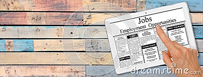 Banner Online job hunting Hand with computer tablet reading employment ads on table Stock Photo