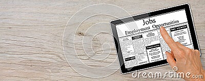 Banner Online job hunting Hand with computer tablet reading employment ads on table Stock Photo