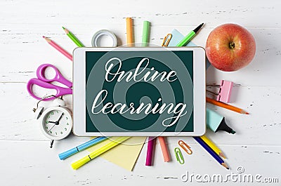 Online learning - handwritten inscription on a tablet. The concept of distance training for children. Tablet and office supplies Stock Photo