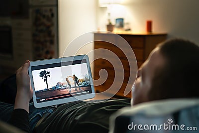 Online movie stream in tablet screen home at night. Man watching on demand film streaming service or music video. Tv series in VOD Stock Photo