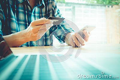 Online payment, man's hands holding a credit card and using smar Stock Photo