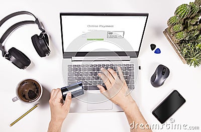 Online payments top view concept. Man is shopping online and paying with credit card. Desk flat lay view with laptop, mobile Stock Photo