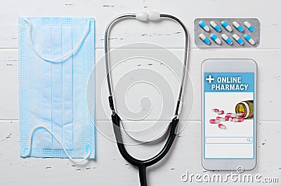 Online pharmacy. Application in smartphone for online ordering of medicines. Medical disposable face mask and the phone on a white Stock Photo