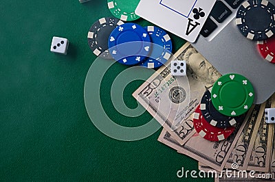 Online poker chips and dice near the keyboard on the gaming green table Stock Photo