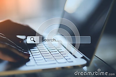 Online searching concept with human hands typing on laptop keyboard and search bar Stock Photo