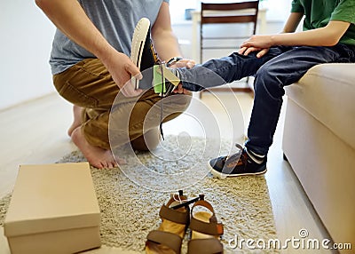 Online shopping for baby and kids. Father helping fitting shoes for his child at home. Free of charge courier delivery from online Stock Photo