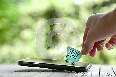 Online shopping concept: a paper shopping cart on a mobile phone Stock Photo